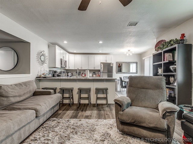 4640 E 68th St Unit 285, Tulsa, OK 74136 - living area with ceiling fan, wood finished floors, a textured ceiling, and recessed lighting