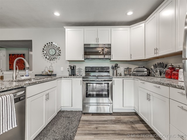 4640 E 68th St Unit 285, Tulsa, OK 74136 - kitchen with stainless steel appliances, white cabinetry, recessed lighting, light stone counters, and light wood-style flooring