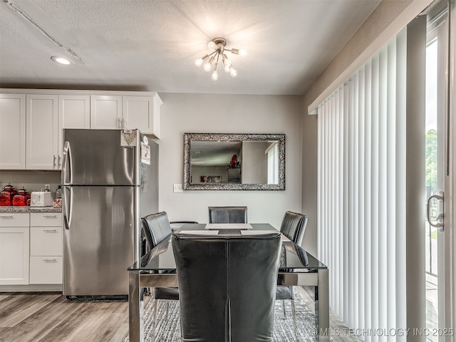 4640 E 68th St Unit 285, Tulsa, OK 74136 - dining area featuring healthy amount of natural light, light wood-style floors, and a textured ceiling