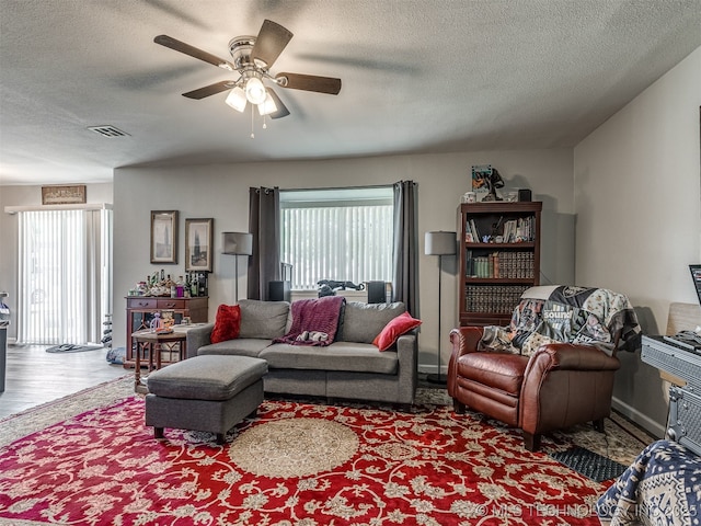 4640 E 68th St Unit 185, Tulsa, OK 74136 - living room featuring a textured ceiling, a ceiling fan, and wood finished floors