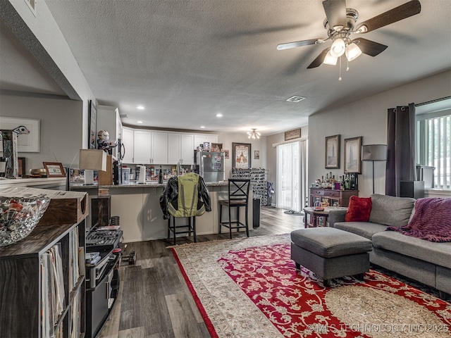 4640 E 68th St Unit 185, Tulsa, OK 74136 - living room featuring a ceiling fan, dark wood-type flooring, a textured ceiling, and recessed lighting