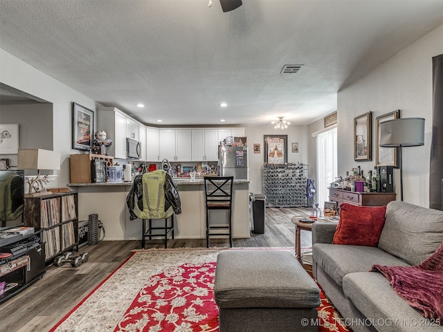 4640 E 68th St Unit 185, Tulsa, OK 74136 - living area featuring wood finished floors, a textured ceiling, and recessed lighting