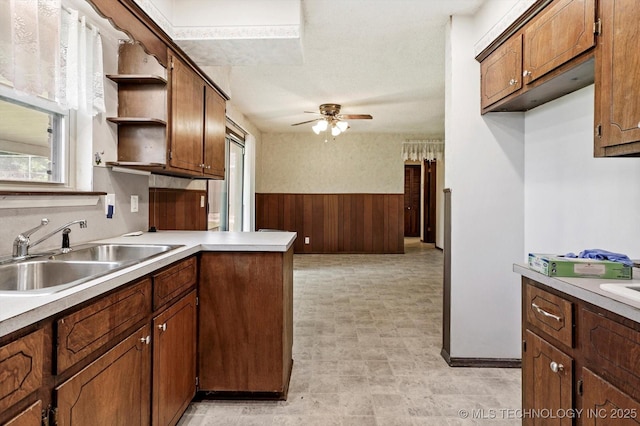 16429 E 1st St, Tulsa, OK 74108 - kitchen with open shelves, ceiling fan, a peninsula, light countertops, and brown cabinetry