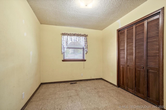 16429 E 1st St, Tulsa, OK 74108 - unfurnished bedroom featuring a closet, a textured ceiling, and light colored carpet