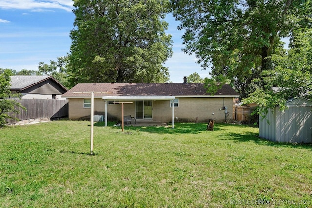16429 E 1st St, Tulsa, OK 74108 - rear view of property with a fenced backyard, a storage unit, a patio area, and brick siding