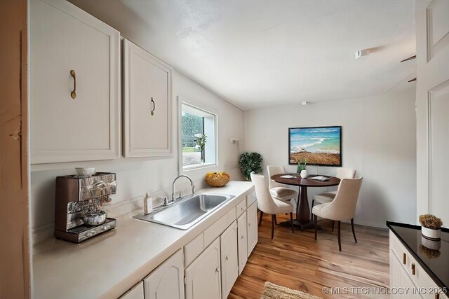 20910 Blackjack Trl, Kellyville, OK 74039 - kitchen with light wood-style floors and white cabinetry