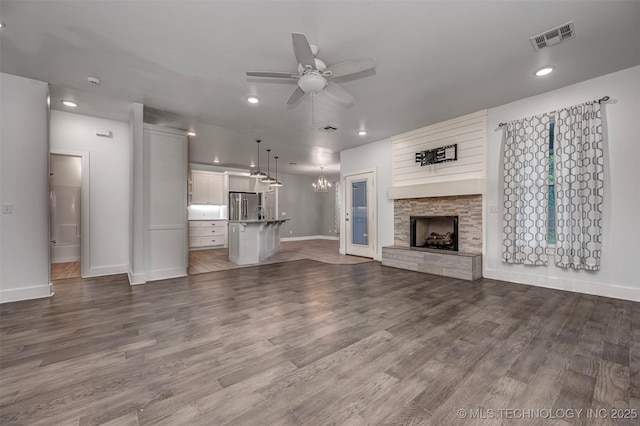 1341 Alvera Ln, Wynnewood, OK 73098 - unfurnished living room featuring a ceiling fan, recessed lighting, a fireplace, wood finished floors, and a chandelier