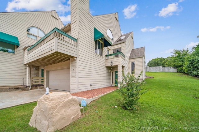 5743 E 72nd Pl Unit 11, Tulsa, OK 74136 - back of property featuring a balcony, concrete driveway, a chimney, and a garage