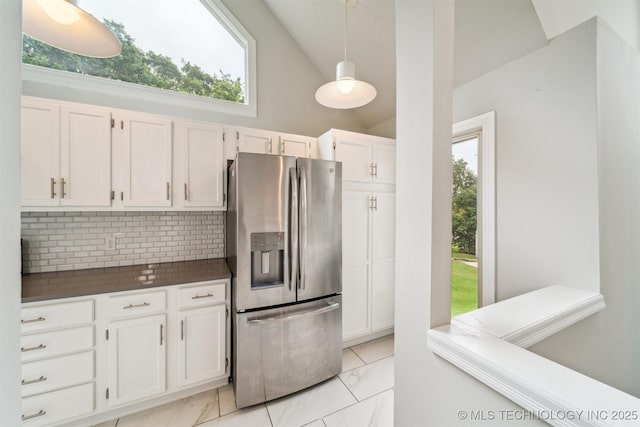 5743 E 72nd Pl Unit 11, Tulsa, OK 74136 - kitchen with stainless steel fridge with ice dispenser, dark countertops, tasteful backsplash, white cabinetry, and plenty of natural light