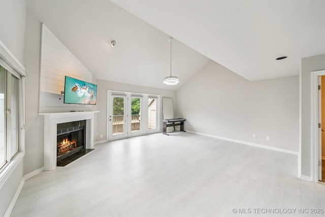 5743 E 72nd Pl Unit 11, Tulsa, OK 74136 - unfurnished living room with a fireplace, vaulted ceiling, and wood finished floors