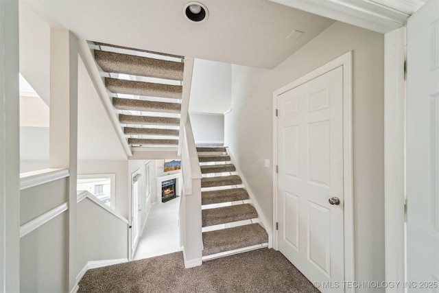 5743 E 72nd Pl Unit 11, Tulsa, OK 74136 - stairs with carpet and a lit fireplace