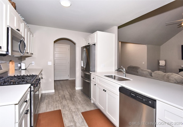 10718 S 279th Ave E, Coweta, OK 74429 - kitchen featuring stainless steel appliances, white cabinetry, arched walkways, light countertops, and open floor plan