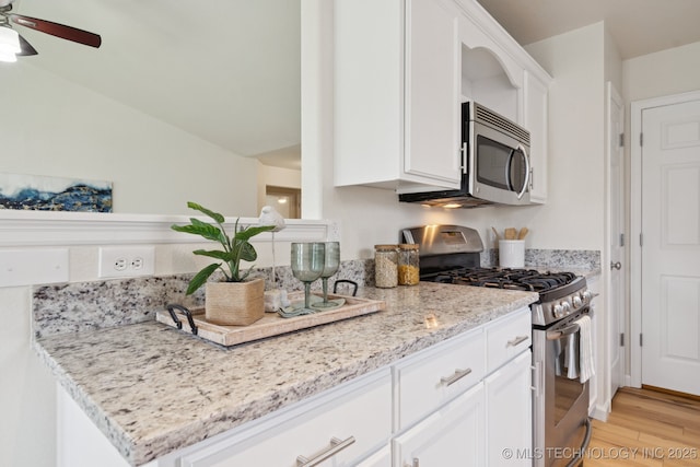 2211 E Concord Pl, Broken Arrow, OK 74012 - kitchen with stainless steel appliances, white cabinetry, light wood-type flooring, ceiling fan, and light stone counters