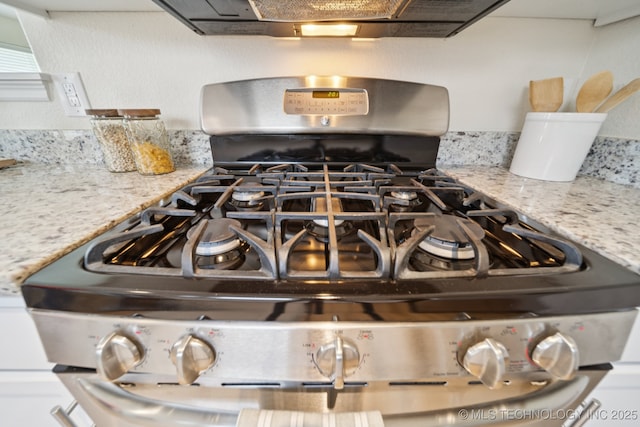 2211 E Concord Pl, Broken Arrow, OK 74012 - kitchen view of stainless steel gas stove, ventilation hood, and light stone countertops