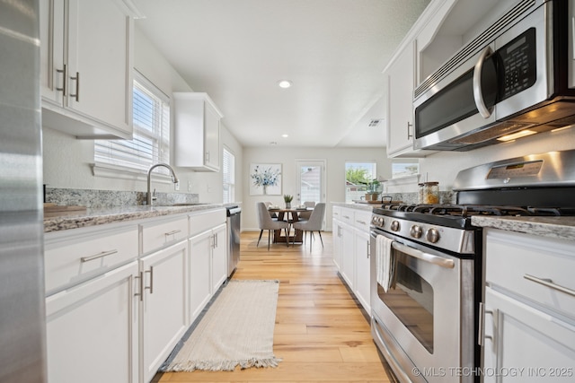 2211 E Concord Pl, Broken Arrow, OK 74012 - kitchen featuring stainless steel appliances, light wood finished floors, plenty of natural light, white cabinetry, and recessed lighting