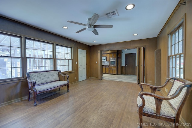 583 S Joplin Ave, Tulsa, OK 74112 - living area with healthy amount of natural light, light wood-style floors, recessed lighting, a ceiling fan, and wooden walls