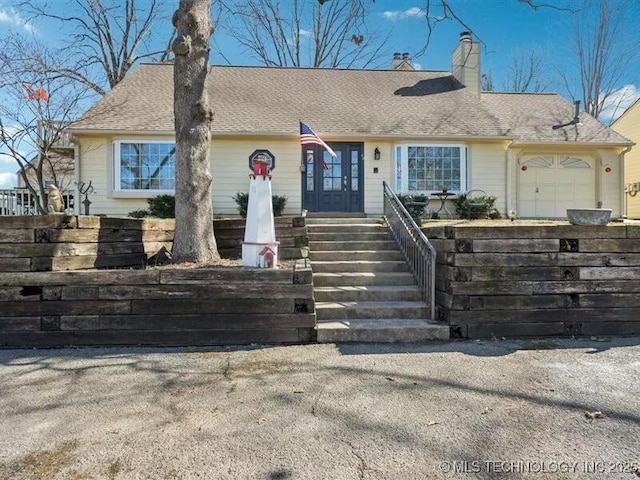 31990 S 624th Pl Unit 48, Grove, OK 74344 - view of front of property featuring a garage, a chimney, and roof with shingles