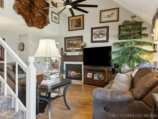 31990 S 624th Pl Unit 48, Grove, OK 74344 - living area with ceiling fan, lofted ceiling, wood finished floors, a warm lit fireplace, and stairs
