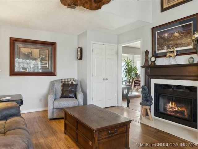 31990 S 624th Pl Unit 48, Grove, OK 74344 - living room with wood finished floors, a fireplace with flush hearth, and a textured ceiling