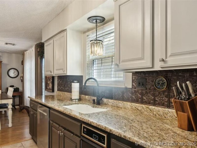 31990 S 624th Pl Unit 48, Grove, OK 74344 - kitchen with a textured ceiling, light stone countertops, tasteful backsplash, decorative light fixtures, and white cabinetry