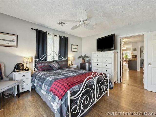 31990 S 624th Pl Unit 48, Grove, OK 74344 - bedroom featuring wood finished floors, a textured ceiling, and ceiling fan