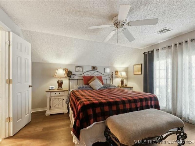 31990 S 624th Pl Unit 48, Grove, OK 74344 - bedroom featuring a textured ceiling, wood finished floors, vaulted ceiling, and ceiling fan
