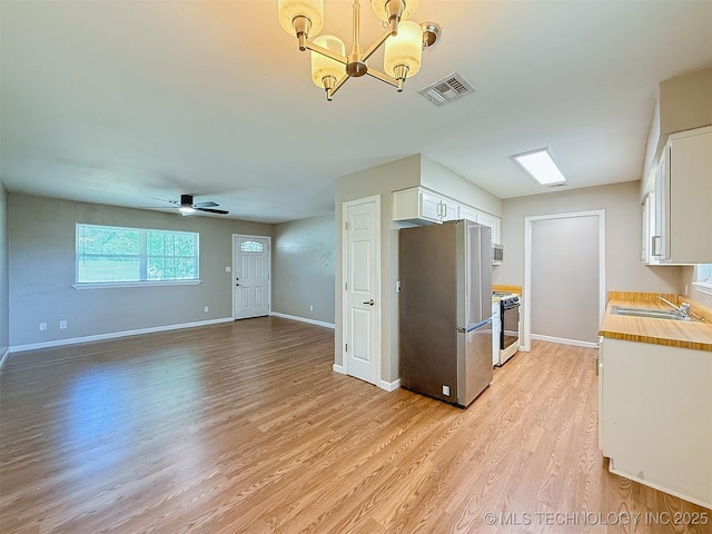 3700 Bloomfield Loop, Ada, OK 74820 - kitchen with freestanding refrigerator, white cabinetry, light wood-type flooring, a chandelier, and white gas range oven