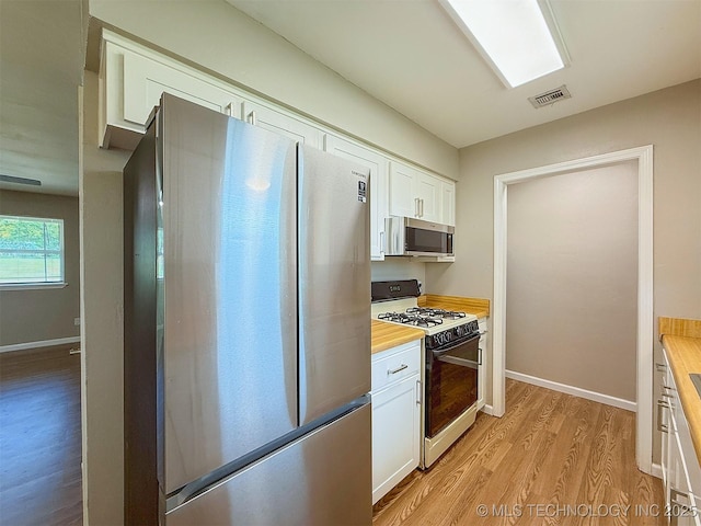 3700 Bloomfield Loop, Ada, OK 74820 - kitchen featuring stainless steel appliances, light wood finished floors, white cabinetry, and wood counters