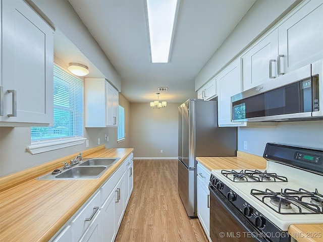 3700 Bloomfield Loop, Ada, OK 74820 - kitchen featuring white gas range oven, stainless steel microwave, white cabinets, and light countertops