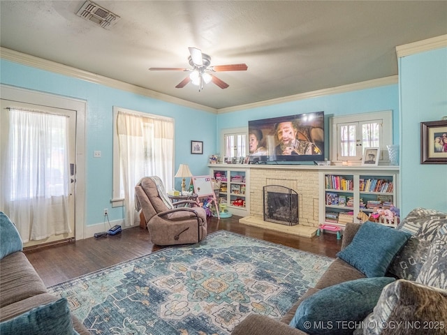621 E Seminole Ave, Mcalester, OK 74501 - living area with wood finished floors, a ceiling fan, a fireplace, crown molding, and plenty of natural light