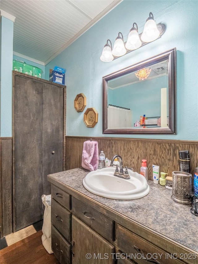 621 E Seminole Ave, Mcalester, OK 74501 - full bathroom with vanity, wainscoting, ornamental molding, wood finished floors, and wooden walls