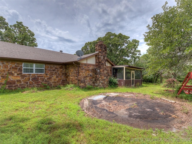 28265 Forest Ridge Rd, Sand Springs, OK 74063 - rear view of property featuring stone siding, a sunroom, a chimney, a yard, and a shingled roof