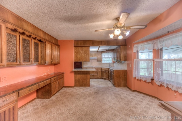 28265 Forest Ridge Rd, Sand Springs, OK 74063 - kitchen with brown cabinetry, a ceiling fan, a textured ceiling, dishwasher, and a peninsula