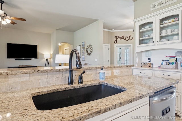 5814 130th W Ave, Sand Springs, OK 74063 - kitchen with light stone counters, glass insert cabinets, a ceiling fan, white cabinets, and ornamental molding
