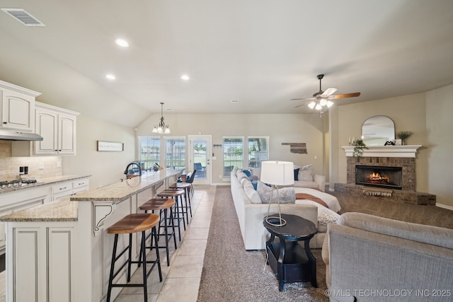 5814 130th W Ave, Sand Springs, OK 74063 - living area featuring a ceiling fan, a brick fireplace, light tile patterned floors, recessed lighting, and vaulted ceiling