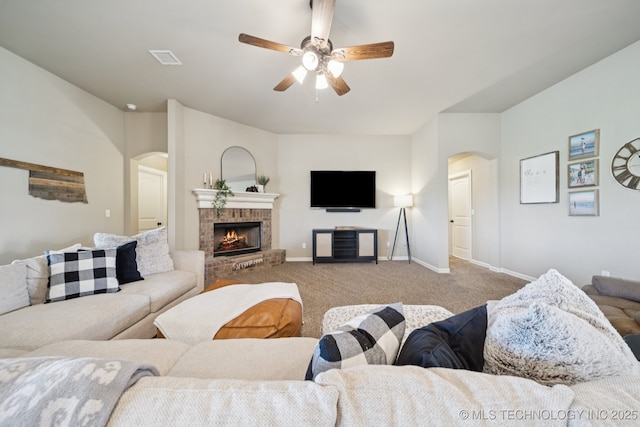 5814 130th W Ave, Sand Springs, OK 74063 - living area with arched walkways, carpet, ceiling fan, and a fireplace