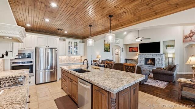 14934 S Sequoia St, Glenpool, OK 74033 - kitchen featuring stainless steel appliances, wood ceiling, a ceiling fan, custom range hood, and a fireplace