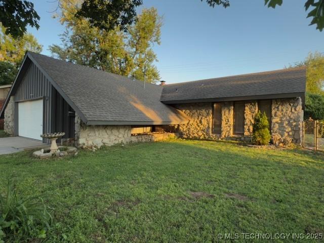104 E 58th St, Tulsa, OK 74105 - view of front facade with stone siding, a garage, board and batten siding, and a shingled roof