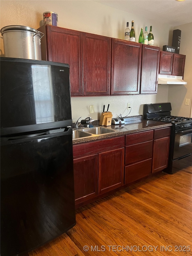 1215 S Quincy Ave, Tulsa, OK 74120 - kitchen with black appliances, dark brown cabinets, dark countertops, dark wood-style floors, and under cabinet range hood