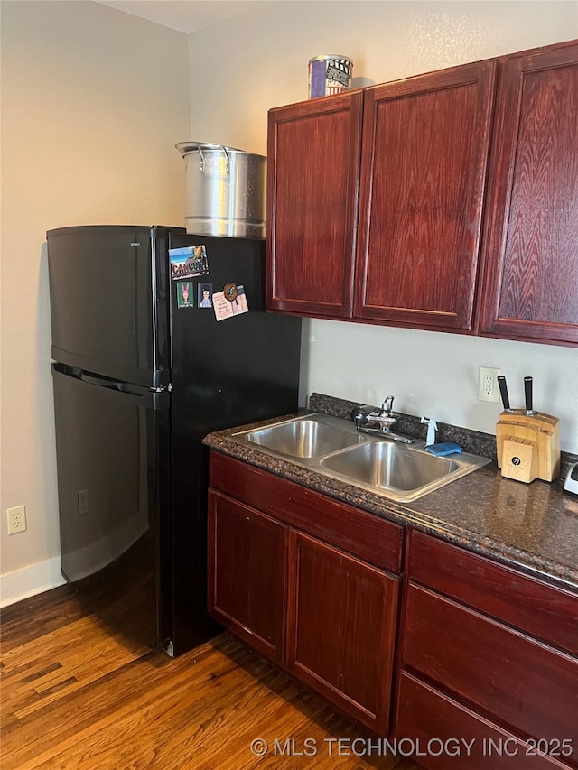 1215 S Quincy Ave, Tulsa, OK 74120 - kitchen featuring dark wood-style flooring, freestanding refrigerator, and reddish brown cabinets