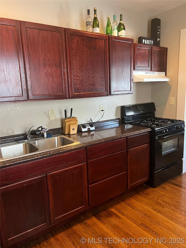 1215 S Quincy Ave, Tulsa, OK 74120 - kitchen with gas stove, under cabinet range hood, reddish brown cabinets, dark wood finished floors, and dark stone counters
