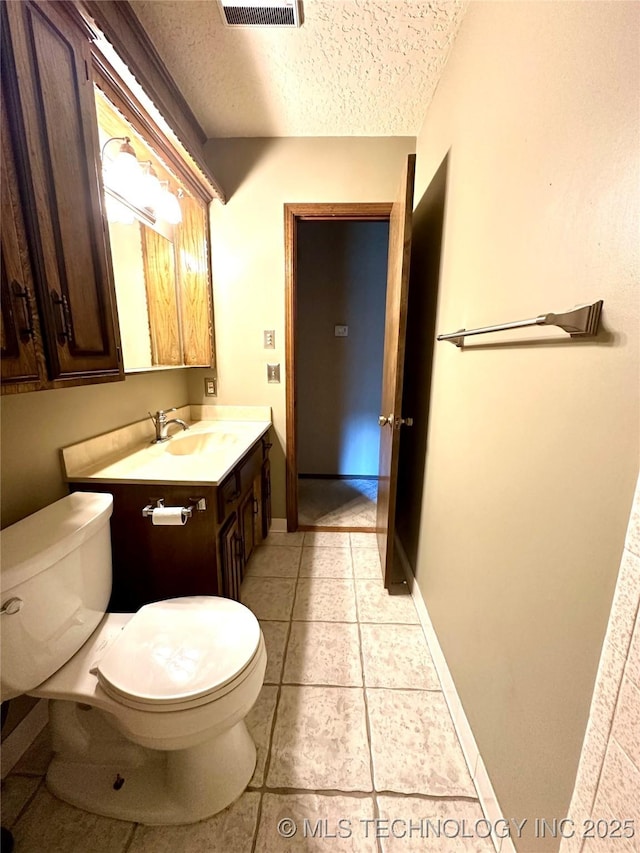 204 E 24th Ct, Owasso, OK 74055 - half bathroom with vanity, a textured ceiling, and tile patterned flooring