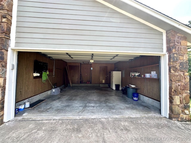 204 E 24th Ct, Owasso, OK 74055 - garage featuring freestanding refrigerator, driveway, and a garage door opener