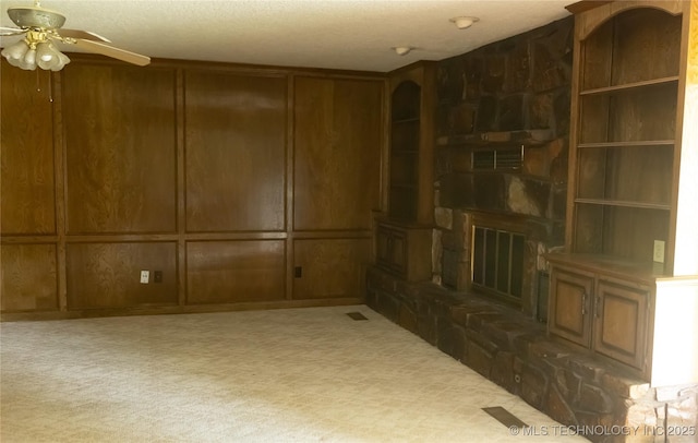 204 E 24th Ct, Owasso, OK 74055 - unfurnished living room with a ceiling fan, a stone fireplace, and a decorative wall