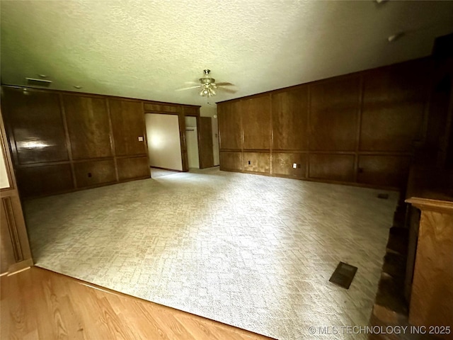 204 E 24th Ct, Owasso, OK 74055 - spare room with ceiling fan, wood walls, and a decorative wall