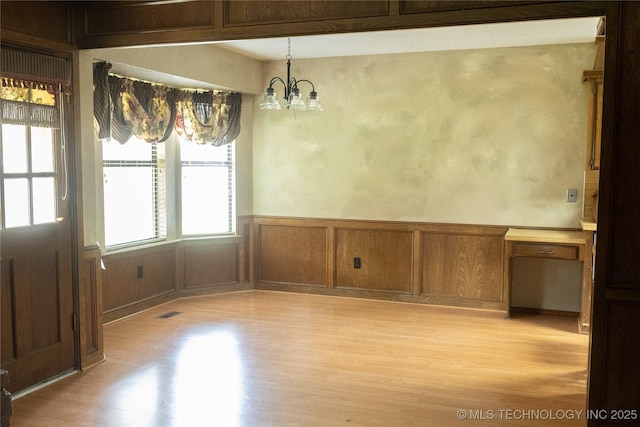 204 E 24th Ct, Owasso, OK 74055 - unfurnished dining area featuring light wood-style flooring, a chandelier, and wainscoting