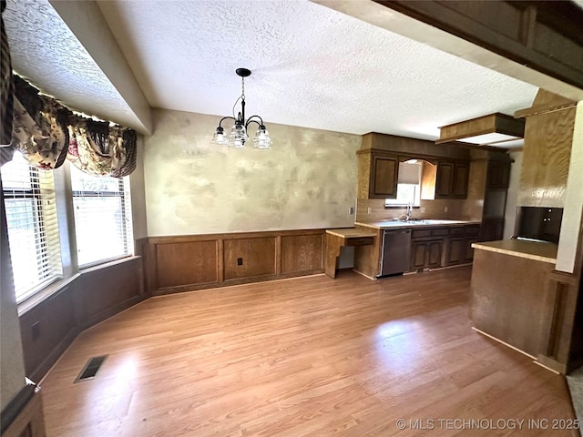 204 E 24th Ct, Owasso, OK 74055 - kitchen with light wood finished floors, a chandelier, a textured ceiling, dishwasher, and plenty of natural light