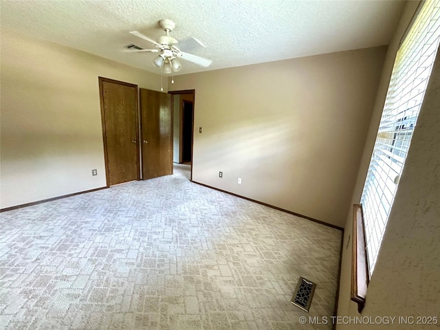 204 E 24th Ct, Owasso, OK 74055 - unfurnished bedroom with brick patterned flooring, a closet, a textured ceiling, and ceiling fan