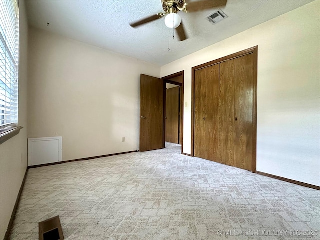 204 E 24th Ct, Owasso, OK 74055 - unfurnished bedroom with a closet, a textured ceiling, carpet, and a ceiling fan