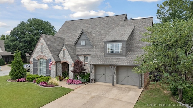5117 E 92nd St, Tulsa, OK 74137 - view of front of house with stone siding, an attached garage, concrete driveway, a front yard, and a shingled roof